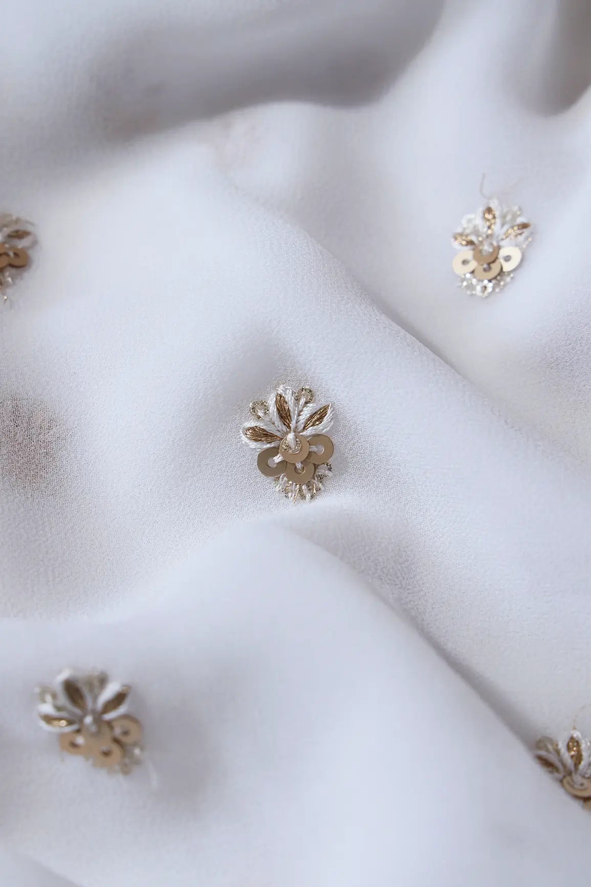 AIzaSyBcstauz-XMPRhEY21AUzeo032pxrXB5Ug - Gold Sequins With Zari Small Floral Booti Embroidery On White Georgette Fabric