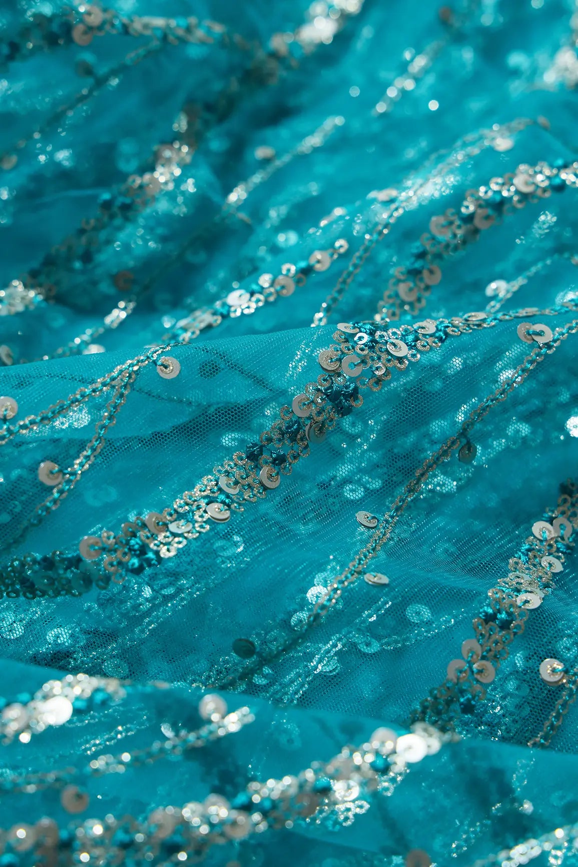 AIzaSyBcstauz-XMPRhEY21AUzeo032pxrXB5Ug - Gold And Silver Sequins With Peacock Blue Thread Wavy Embroidery On Peacock Blue Soft Net Fabric