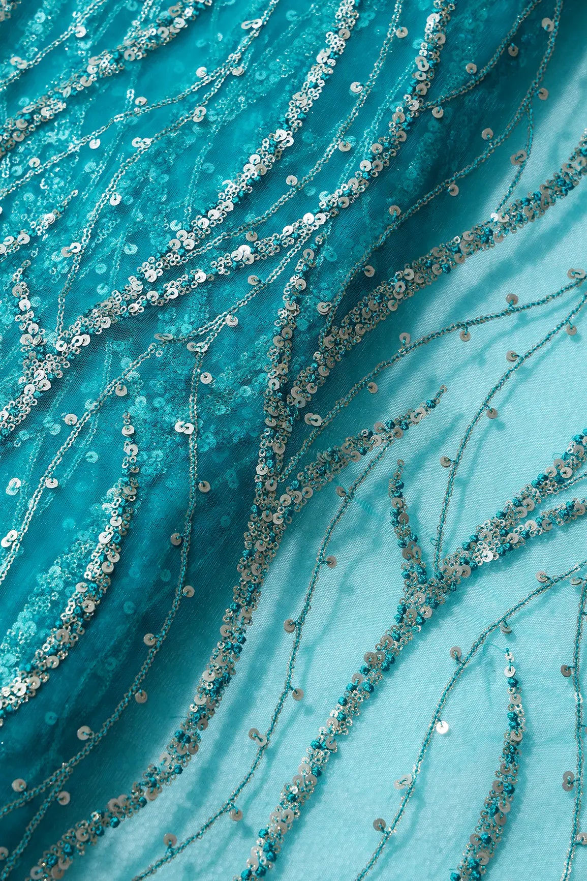 AIzaSyBcstauz-XMPRhEY21AUzeo032pxrXB5Ug - Gold And Silver Sequins With Peacock Blue Thread Wavy Embroidery On Peacock Blue Soft Net Fabric