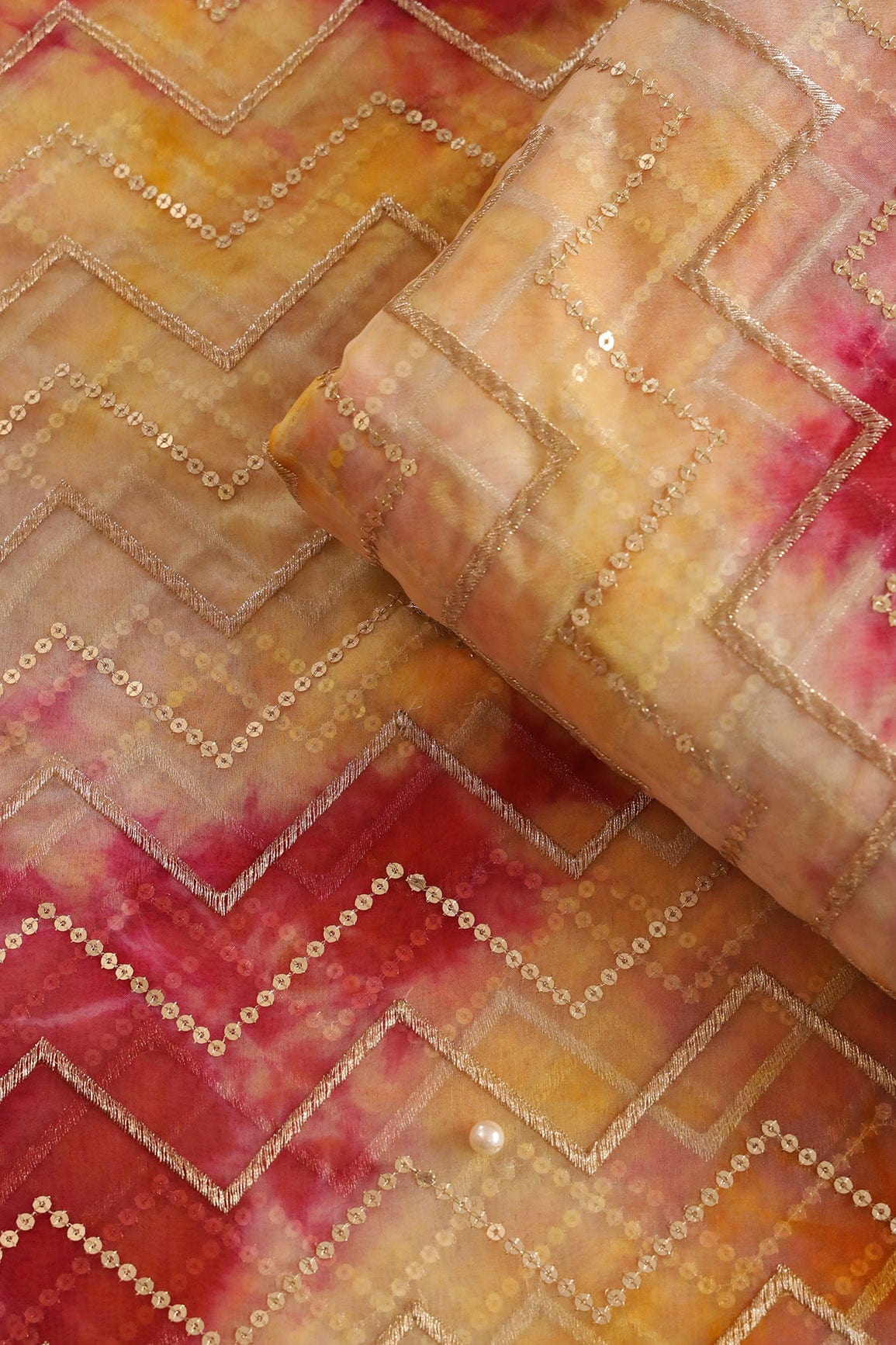 AIzaSyBcstauz-XMPRhEY21AUzeo032pxrXB5Ug - Gold Zari With Gold Sequins Chevron Embroidery Work On Tie & Dye Dark Pink And Yellow Organza Fabric