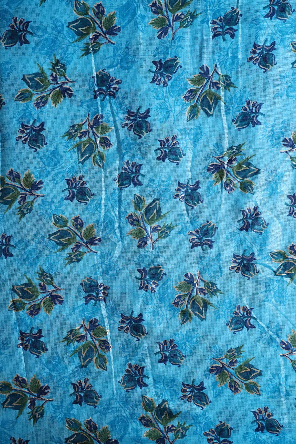 AIzaSyBcstauz-XMPRhEY21AUzeo032pxrXB5Ug - Blue And Green Floral Pattern Foil Print On Sky Blue Kota Doria Fabric